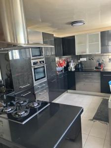 a kitchen with a black counter top in a room at Beau Rez de Jardin in Ariana