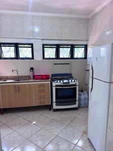 a kitchen with a stove and a refrigerator at quarto suíte privativo em campinas para até 3 pessoas in Campinas