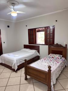 a bedroom with two beds and a window at quarto suíte privativo em campinas para até 3 pessoas in Campinas
