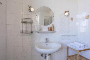 ein weißes Badezimmer mit Waschbecken und Spiegel in der Unterkunft Hotel Jaro in Mělník