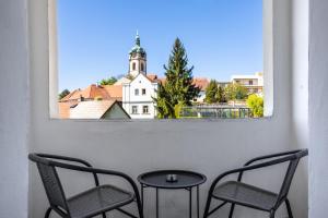 zwei Stühle und ein Tisch vor einem Fenster in der Unterkunft Hotel Jaro in Mělník + 16 Fotos