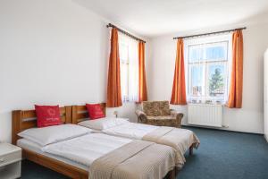 ein Schlafzimmer mit zwei Betten und einem Stuhl in der Unterkunft Hotel Jaro in Mělník