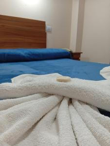 a white blanket laying on top of a bed at Hotel Ke Kuul in Salta