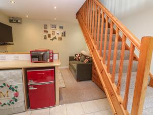 a kitchen with a red refrigerator and a staircase at Mini Mena in St Austell +8 photos