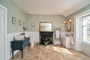 a bathroom with a fireplace and a sink and a mirror at Kirkland in Berwick-Upon-Tweed