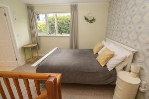 a bedroom with a bed and a window at Mini Mena in St Austell