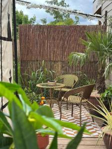 a patio with a table and chairs and a fence at Lodge SAHARA in Arques