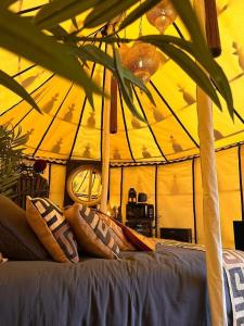 a couch in a tent with pillows on it at Lodge SAHARA in Arques