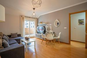 a living room with a couch and a table at Terraza y Parking - Ático Capitán - Koti Rentals in Fuengirola