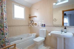 a bathroom with a toilet and a sink and a tub at Terraza y Parking - Ático Capitán - Koti Rentals in Fuengirola +33 photos