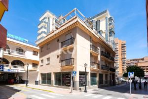 a building on a street in a city with at Terraza y Parking - Ático Capitán - Koti Rentals in Fuengirola