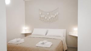 a bedroom with a bed with two towels on it at Maison La Chicca in Molfetta +21 photos