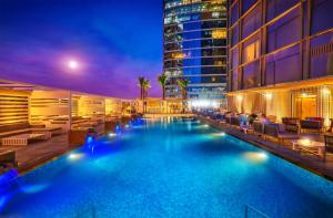 a swimming pool in a hotel at night at Media One Hotel Dubai, WorldHotels Crafted in Dubai