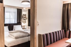 een hotelkamer met een bed en een stoel bij A Casa Smaragd Appartements in Sölden +32 foto's
