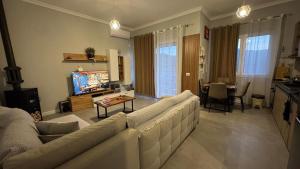 a living room with a couch and a tv at Agnesa Apartament in Gramsh