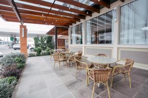 an outdoor patio with tables and chairs and windows at Hotel Prata Villaggio in Nova Prata