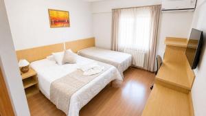 a hotel room with two beds and a television at Hotel Prata Villaggio in Nova Prata