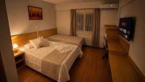 a hotel room with two beds and a television at Hotel Prata Villaggio in Nova Prata