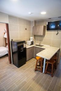 a kitchen with a black refrigerator and a table at Edificios Refugio in Nevados de Chillan