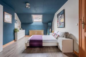 a bedroom with a bed and a blue wall at Brussels Guest House in Brussels