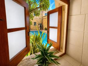 an open window with a view of a swimming pool at Ta' Matmura Boutique B&B in Għarb +36 photos