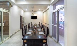 a long dining room with a long table and chairs at Treebo AK Residency, Tapovan in Kainūr