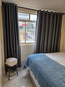 a bedroom with a bed and a window at Apartamento Central in Cascavel +10 photos