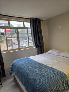 a bedroom with a bed and a large window at Apartamento Central in Cascavel