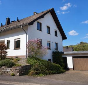 a white house with a garage at de Vinkenborg nabij Winterberg in Winterberg
