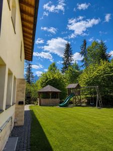 a yard with a playground with a swing at Transylvania Villa & Spa in Gosau