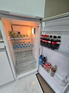 an open refrigerator filled with bottles and drinks at Apartamento Central in Cascavel