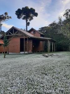 a barn with a field in front of it at Chalés sítio anjo gabriel 3 in Urubici