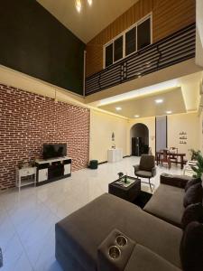 a large living room with a couch and a tv at Cozy Clover house in Hat Yai