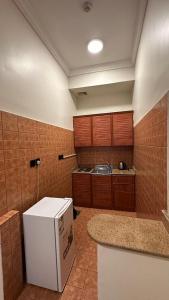 a kitchen with a white refrigerator and a counter at ركن النسيم للشقق الفندقية Rukn Al - Naseam Hotel Apartment in Jeddah