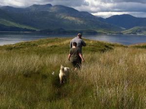 a man and a boy and a dog walking in the grass at Cool Getaway in Appin in Portnacroish