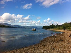 two people walking on the shore of a river at Cool Getaway in Appin in Portnacroish