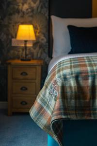 a bedroom with a bed and a lamp on a night stand at Kylesku Hotel & Kylesku House, by Highland Coast Hotels in Kylestrome