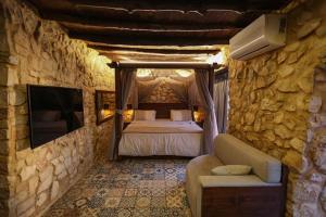 a bedroom with a bed and a stone wall at Beit el loz in Ghazīr +49 photos