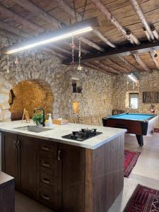 a kitchen with a stove and a pool table at Beit el loz in Ghazīr