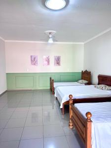 a bedroom with two beds and a white tile floor at quarto suíte privativo em campinas para até 4 pessoas in Campinas