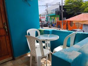 a table and chairs on the side of a blue building at Miss Titi's Native Lodge in San Andrés