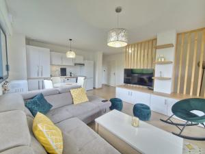 a living room with a gray couch and a kitchen at Le Savannah #Parking#Terrasse in Clermont-Ferrand