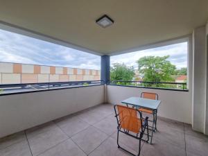 a balcony with a table and chairs and a window at Le Savannah #Parking#Terrasse in Clermont-Ferrand