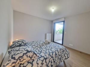 a bedroom with a bed with a comforter and a window at Le Savannah #Parking#Terrasse in Clermont-Ferrand