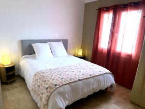a bedroom with a white bed with red curtains at Maison entière cosy calme parking animaux ok in Carcassonne