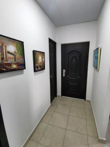 a hallway with a black door and pictures on the wall at Casita del Valle in San Cristóbal