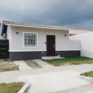 a white house with a door and a driveway at Casita del Valle in San Cristóbal