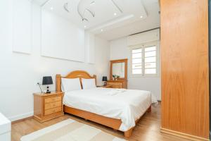 a white bedroom with a bed and a window at Royal Moroccan Suite Central Tangier in Tangier