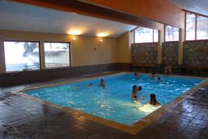 a group of people swimming in a swimming pool at A27 Chalet du Galibier in Valloire