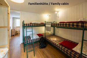 a room with three bunk beds in a room at Camping Jungfrau in Lauterbrunnen